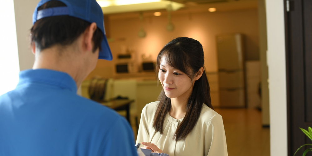 青い作業服を着た作業員と主婦