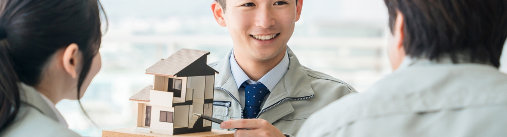 男性作業員が家の模型を持って説明