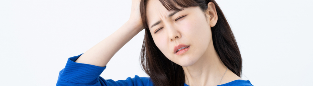女性が頭をおさえて悩んでいる