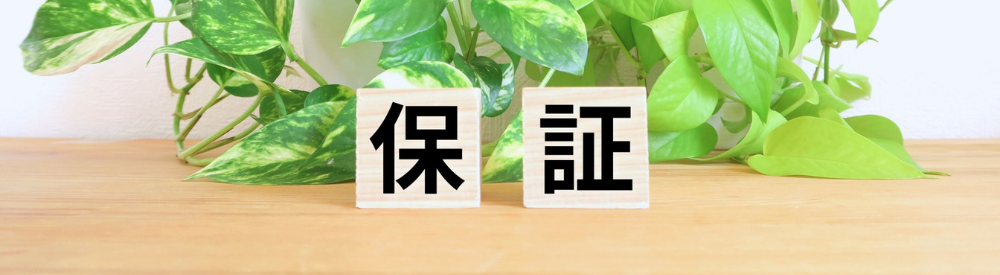 作業服を着た職人が屋根の上で塗装作業をしている様子