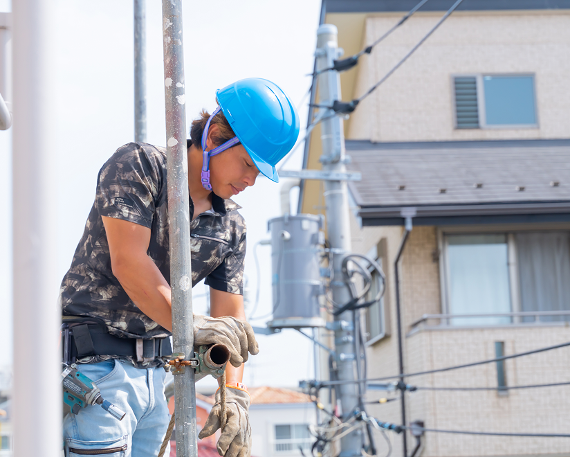 外壁塗装のため足場にいる作業員の様子。