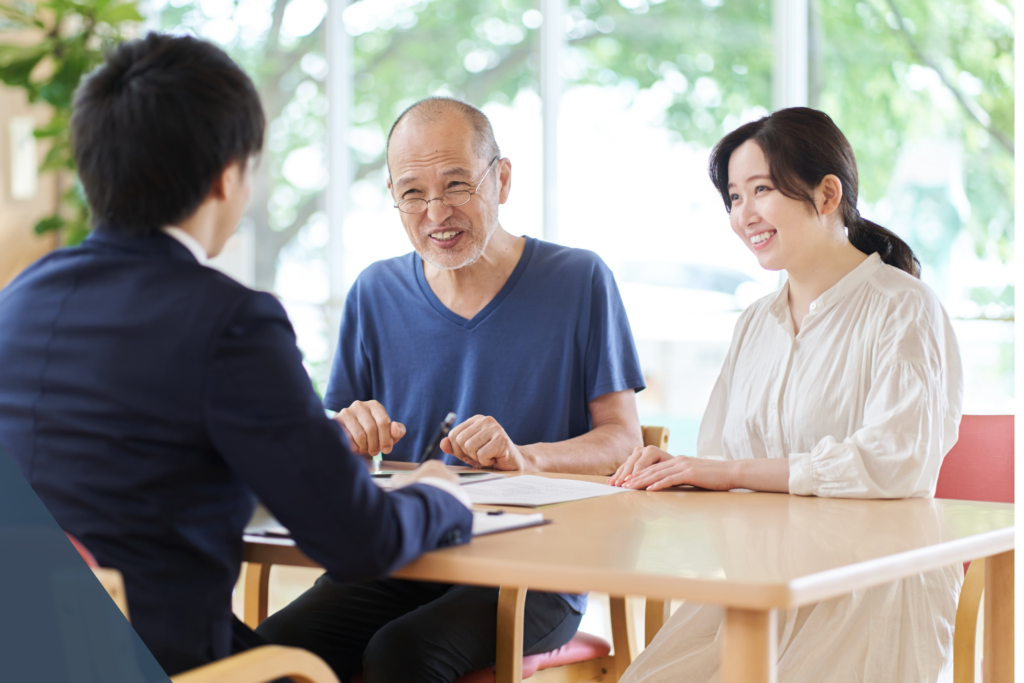 男性と女性がスーツ姿のスタッフと打ち合わせをしている様子。