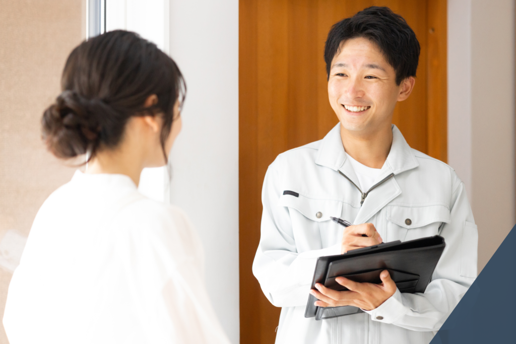 男性作業員が笑顔で女性に対応している様子。