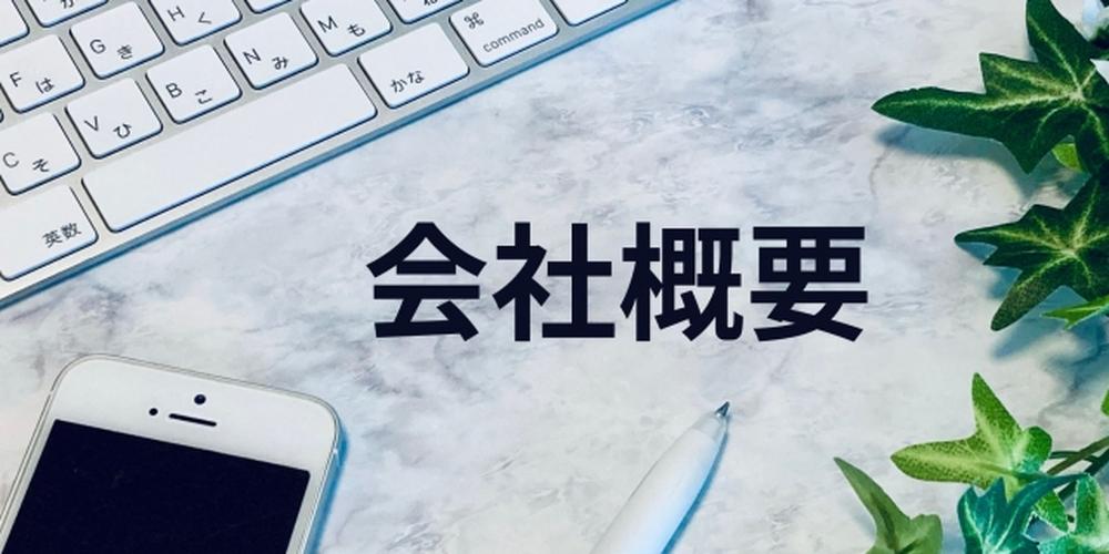 キーボードとスマートフォンが並ぶデスクに「会社概要」の文字