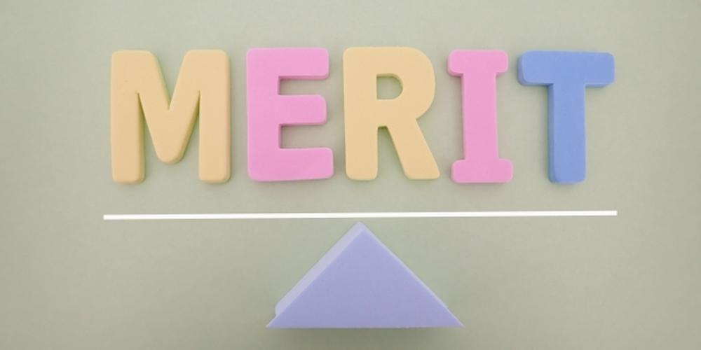 「MERIT」の文字と天秤をイメージした三角形のオブジェ