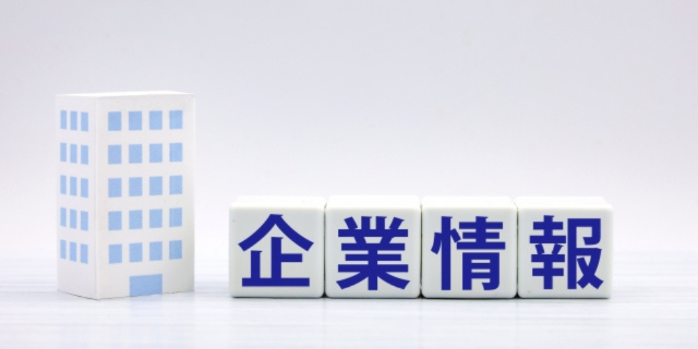 企業情報と書かれたブロックとオフィスビルの模型