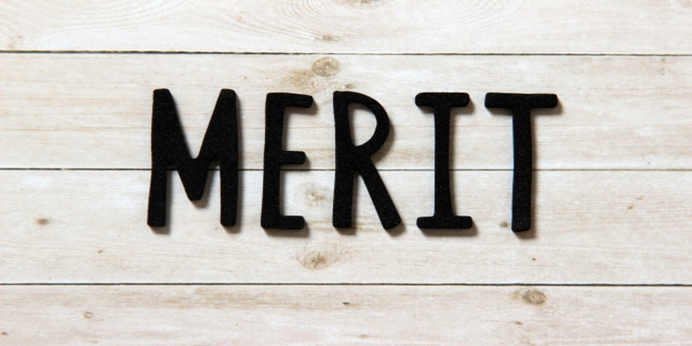 木目調の背景に配置された“MERIT”