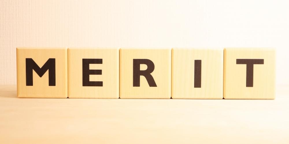 「MERIT」と書かれた木製ブロックが並ぶ、明るくシンプルな背景のイメージ
