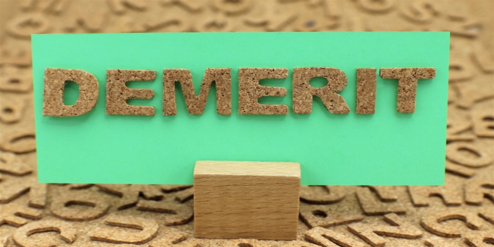 “DEMERIT”の文字がコルク素材で緑のカードに貼られている