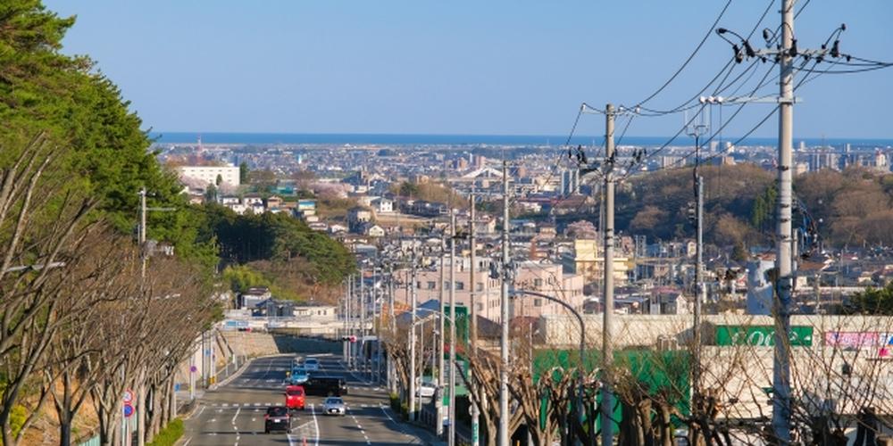 坂道の先に海が広がる都市の風景