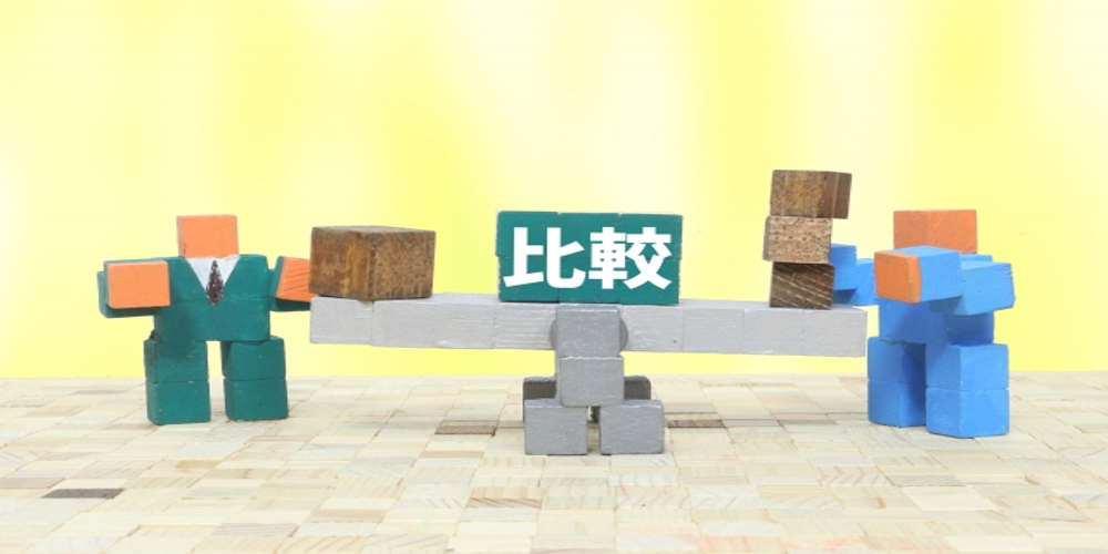比較の文字が書かれた天秤を使ってブロックを持つ2体の人型フィギュア