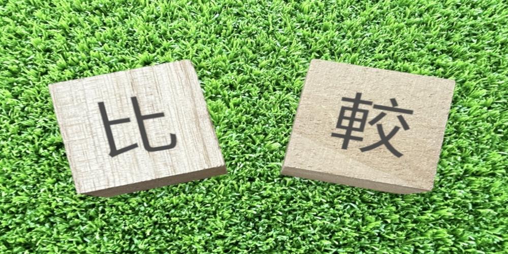芝生の上に置かれた『比較』の木製ブロック