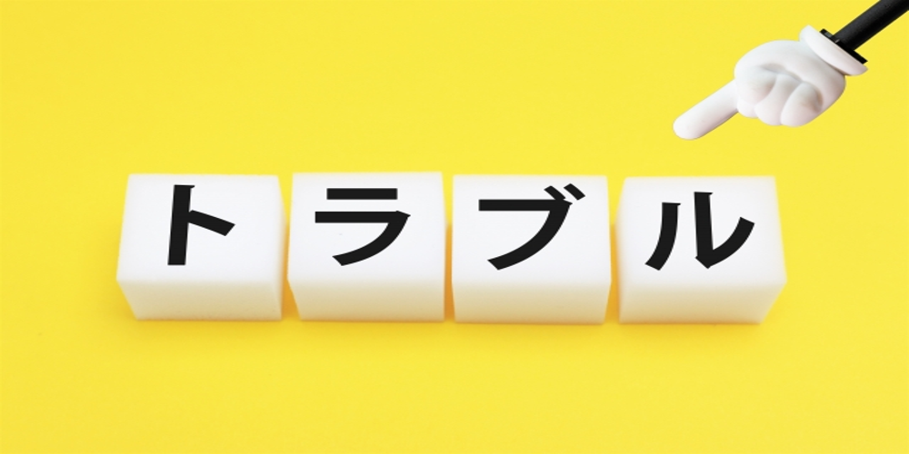 “トラブル”の文字が書かれた白いブロック　指差す手