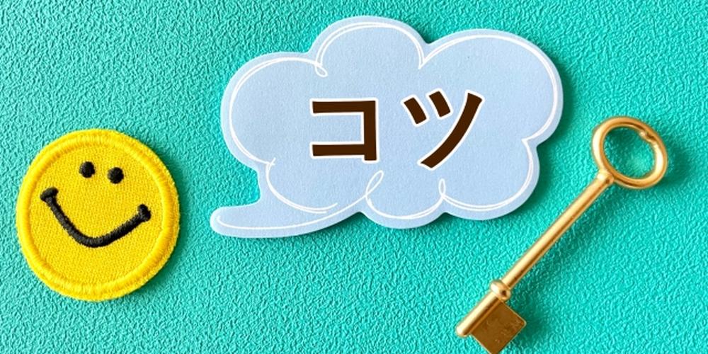 水色の背景の上に「コツ」と書かれた吹き出し、スマイルマーク、金色の鍵