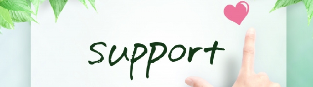 緑の葉に囲まれた背景に「support」と書かれた紙と、右手の人差し指がハートマークに触れている画像