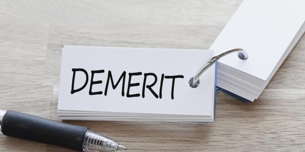 「DEMERIT」と書かれたリングメモとペンが置かれているデメリットのイメージ