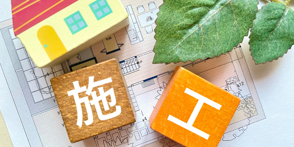 家の図面と「施工」の木製ブロック
