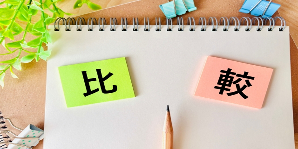 “比較”と書かれた付箋がノートに貼られ、中央に鉛筆が置かれたイメージ。選択や検討を促す視覚表現