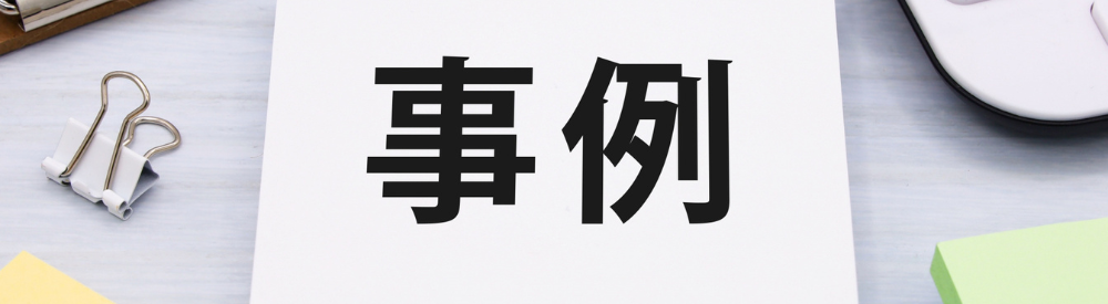 “事例”と書かれたメモ帳と周囲のオフィス用品。成功事例や導入事例を紹介する場面を想起させるビジュアル
