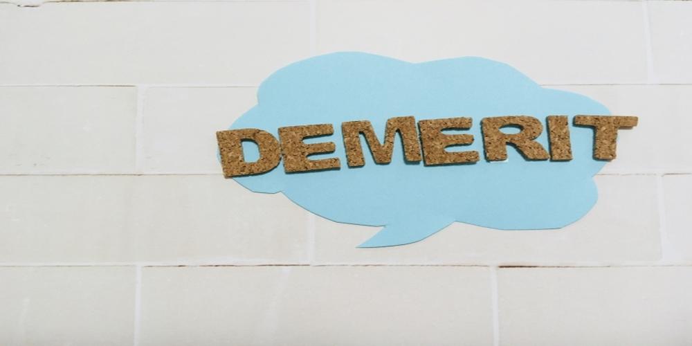 “DEMERIT”の文字がコルク素材で作られた吹き出しに配置されたイメージ。デメリットや課題をソフトな印象で表現したビジュアル。