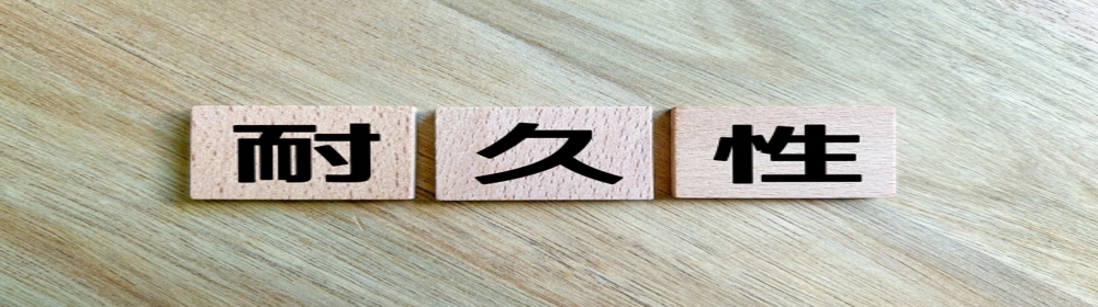 “耐久性”と書かれた木製ブロックが木目の上に並ぶイメージ。長期使用に耐える信頼性を示す