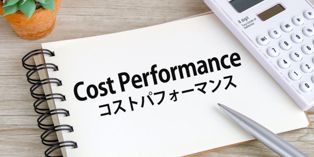 ノートに「Cost Performance コストパフォーマンス」と書かれた文字と電卓・ペンの画像