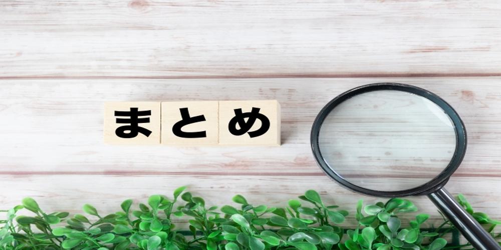“まとめ”の文字がブロックに印字され、虫眼鏡と観葉植物が添えられた木目背景のイメージ。情報整理や総括を視覚的に表現したビジュアル。