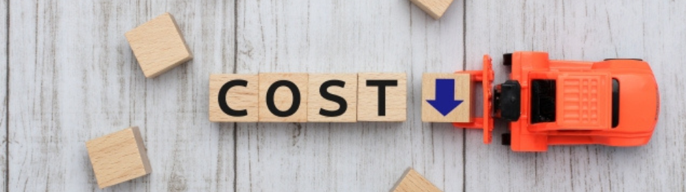 「COST」の文字と青い矢印ブロックをミニカーで押している、コスト削減を表現した画像